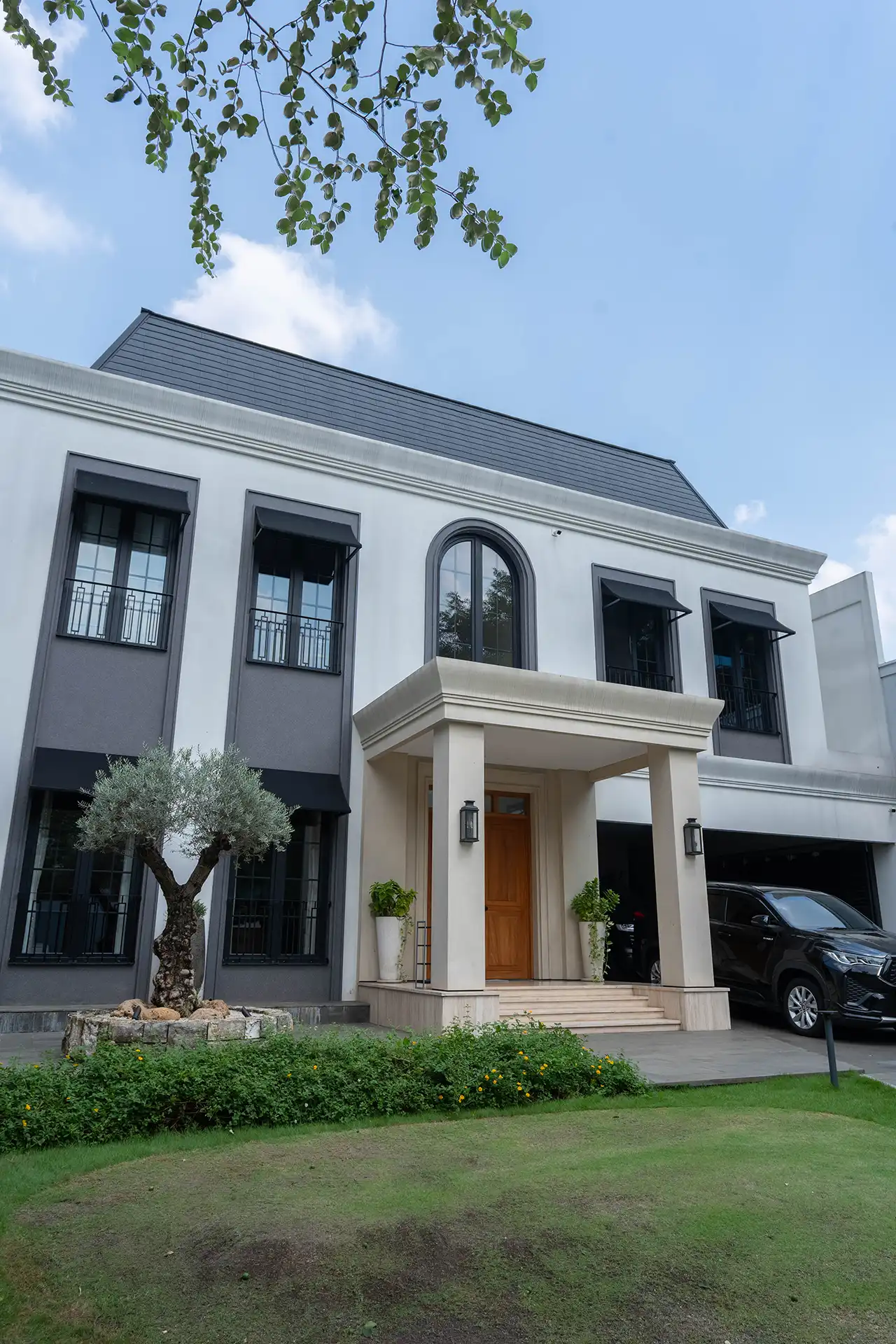 Exterior view of a luxury residence in Permata Hijau featuring anthracite soundproof UPVC windows, an arched window and secure window and door systems with laminated Low-E double glazing.