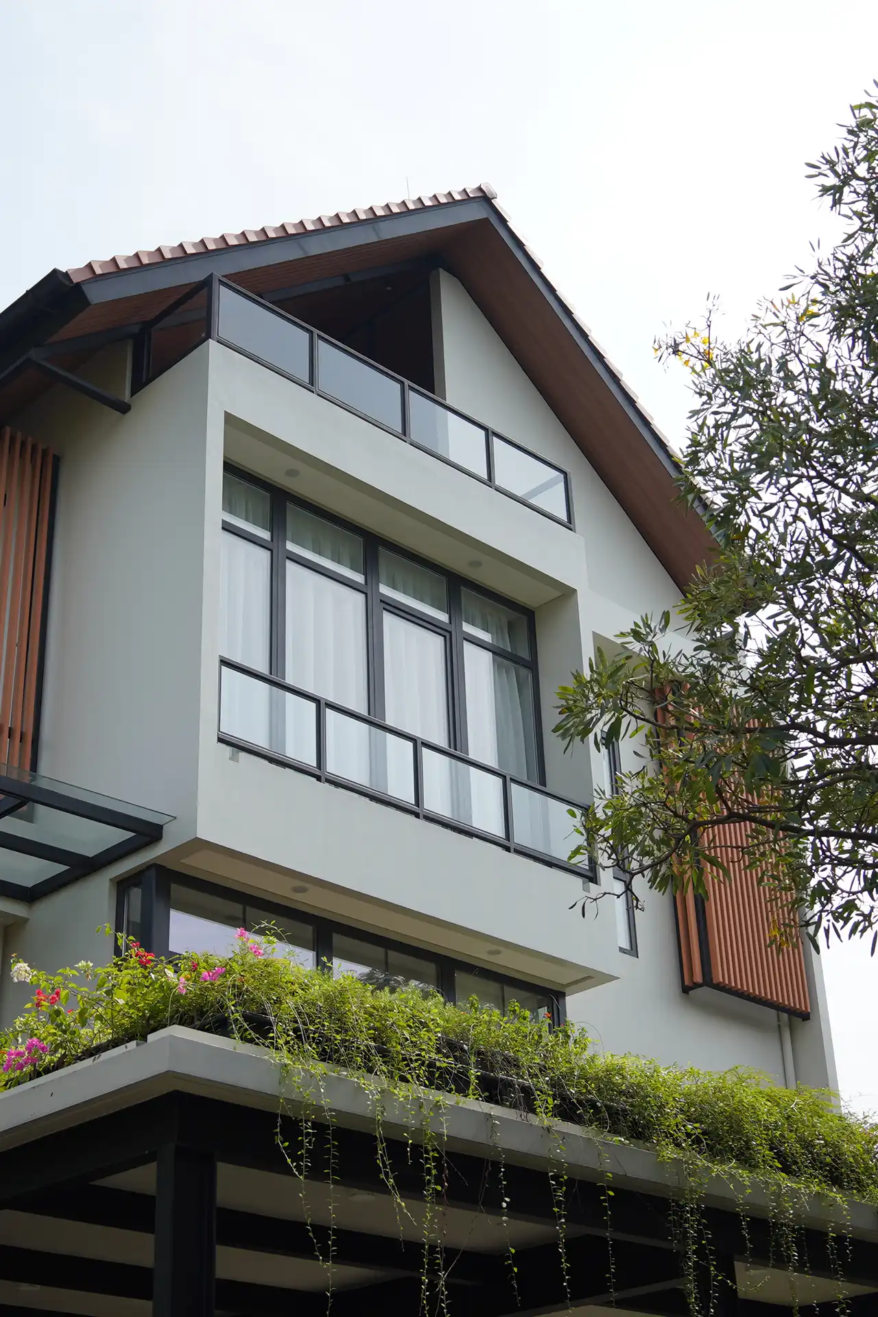 Exterior view of a private residence in South Jakarta featuring dark grey soundproof UPVC windows with insulated glazing.